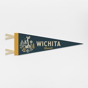 May include: A navy blue pennant with a gold border and cream-colored ties. The pennant features a cream-colored illustration of Wichita, Kansas landmarks and the city's name in white. The word "Kansas" is written in a smaller font below.