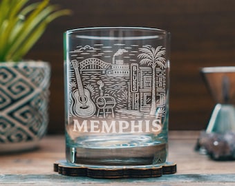 Peut inclure: Un verre transparent gravé d'un motif blanc représentant une guitare, un pont, un bateau à aubes, un palmier et un bâtiment avec le mot BLUES. Le mot MEMPHIS est gravé en grandes lettres capitales au bas du verre.
