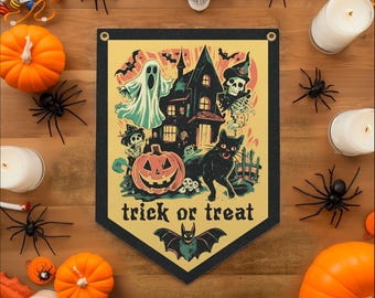 May include: A Halloween-themed banner with a black border, featuring a haunted house, ghost, pumpkin, black cat, and the words "trick or treat." The banner is surrounded by pumpkins, spiders, candles, and a skull on a wooden surface.