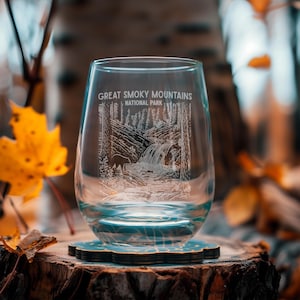 May include: A clear glass wine tumbler with an etched design of a waterfall and a bear in the Great Smoky Mountains National Park.