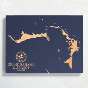 May include: A navy blue map of Grand Bahama & Abacos, Bahamas with a compass rose and the text "Grand Bahama & Abacos Bahamas" in gold.