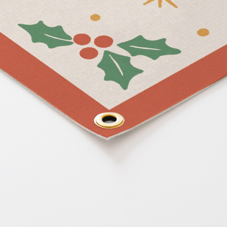 May include: Corner of a banner with a cream background, featuring a red border and gold grommet. The design includes green holly leaves, red berries, and gold starbursts and dots, evoking a festive holiday theme.