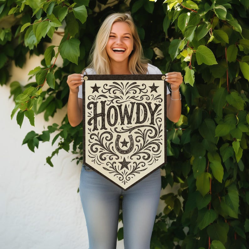 A smiling woman holding a banner with the word "HOWDY" on it.