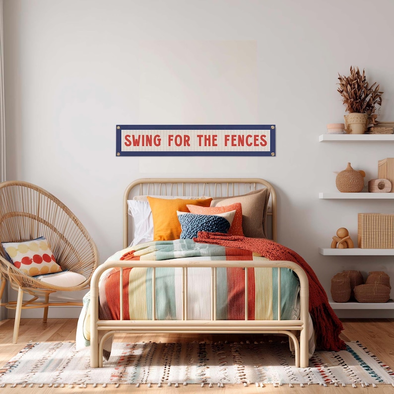 a bedroom with a bed, a wicker chair, and shelves with decorative items. A sign on the wall says "Swing for the Fences".