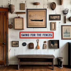 The image is a wall adorned with various framed pictures, a sign, and a bench, creating a rustic and vintage atmosphere.