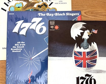 May include: Three vinyl record album covers featuring I Love America by John W. Peterson and Don Wyrtzen, 1776 by The Ray Bloch Singers, and 1776 A New Musical. The covers display an eagle, a firework, and a bird hatching from a Union Jack egg.
