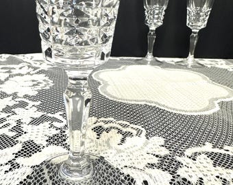 May include: Three clear glass champagne flutes featuring a faceted diamond-cut pattern on the lower bowl and a smooth, slender stem leading to a circular base. The glasses are arranged with one in the foreground and two in the background.