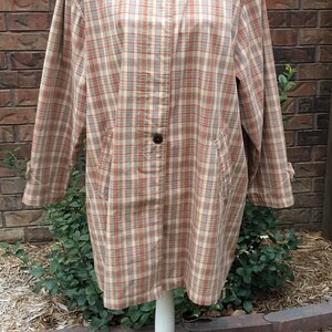 May include: A plaid shirt jacket with a tan corduroy collar. The jacket is on a white mannequin and has a button closure.