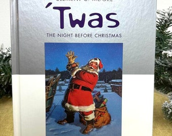 Könnte beinhalten: Ein silbernes Hardcover-Buch mit dem Titel "Twas The Night Before Christmas" in lilafarbener Schrift. Der Umschlag zeigt eine Coca-Cola-Illustration vom Weihnachtsmann.