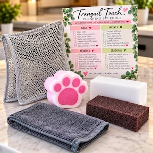 May include: A cleaning kit featuring a gray mesh scrubber, a pink and white paw-shaped sponge, a white melamine sponge, a brown scouring pad, a folded gray microfiber cloth, and a printed card titled Tranquil Touch Cleaning Schedule.