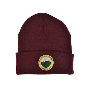 May include: A maroon beanie with a brown embroidered patch that says "Sheriff Department Twin Peaks".