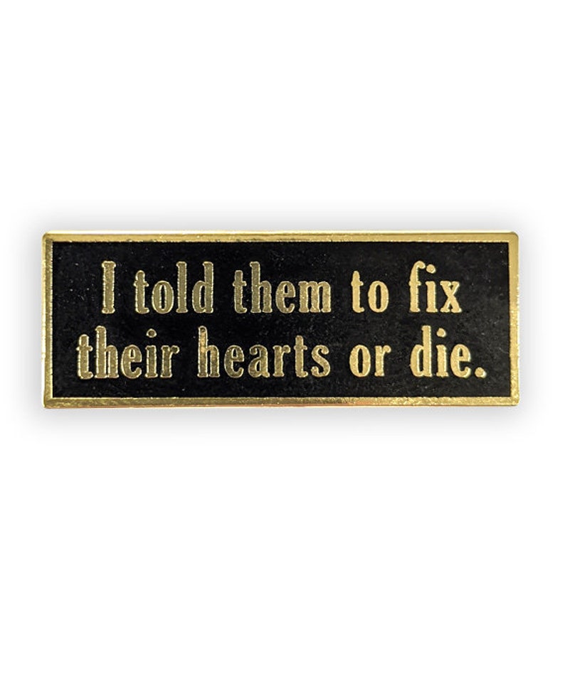 gold pin with "I told them to fix their hearts or die"