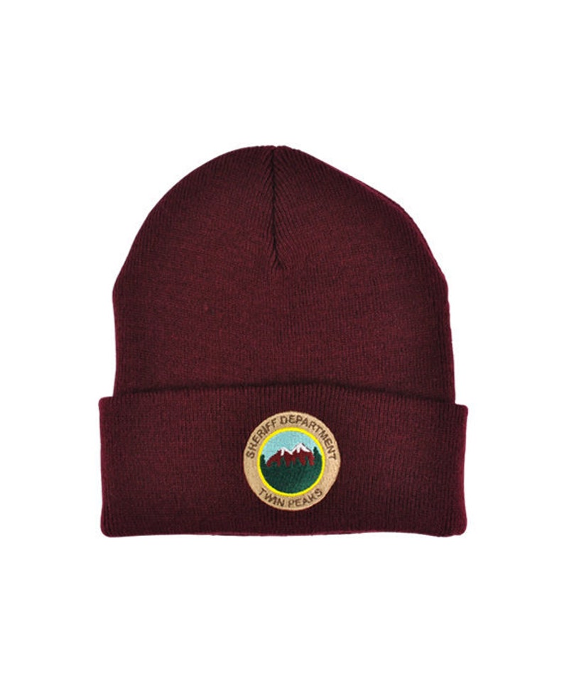 May include: A maroon beanie with a brown embroidered patch that says "Sheriff Department Twin Peaks".