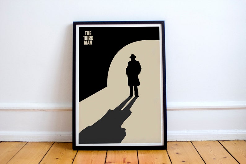 Puede incluir: Un p&oacute;ster minimalista en blanco y negro con el texto "THE THIRD MAN" en blanco. El p&oacute;ster presenta la silueta de un hombre con gabardina caminando hacia afuera, con largas sombras proyectadas sobre un fondo beige.