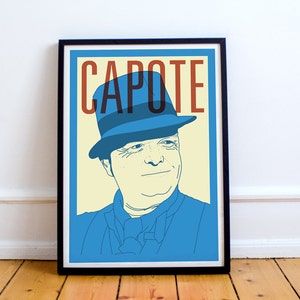May include: A black framed poster with a yellow background and a blue and white illustration of a man wearing a blue hat. The text "CAPOTE" is in red and brown letters.