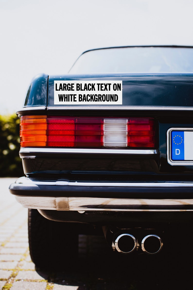 May include: A black car with a white bumper sticker that reads "LARGE BLACK TEXT ON WHITE BACKGROUND".