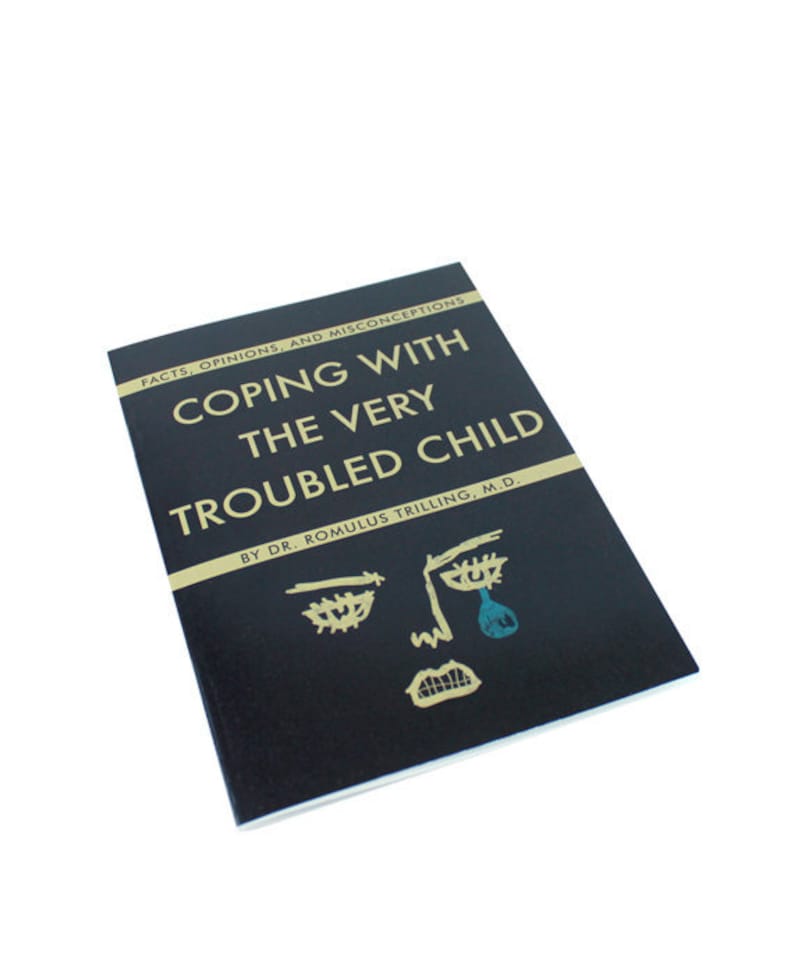 Pu&ograve; includere: Un libro nero con lettere dorate intitolato "Coping with the Very Troubled Child" di Dr. Romulus Trilling, M.D. La copertina presenta un semplice disegno a linea di un viso con una singola lacrima.