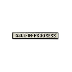 Puede incluir: Un pin rectangular de esmalte con el texto "ISSUE-IN-PROGRESS" en letras mayúsculas negras sobre fondo blanco. El pin tiene un borde negro y está sobre un fondo blanco.