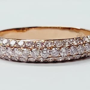 May include: A rose gold band ring with a double row of small, clear diamonds.