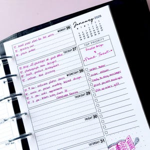 May include: A close-up of a planner page for January 2026, with handwritten notes in purple ink. The planner is open to the week of January 26th, with daily schedules and to-do lists. The top priority is to finalize a design.