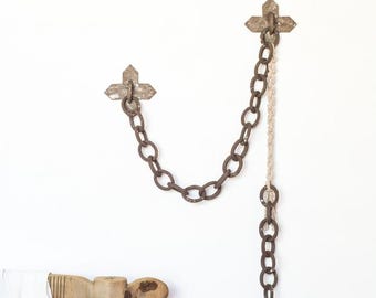 Escultura rústica de macramê para pendurar na parede, feita de cerâmica de grés com elos.