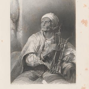May include: Black and white engraving of a man in traditional Middle Eastern attire, holding a hookah. The man has a white turban and beard, and is seated. The image is titled "The Hooka-Badar."
