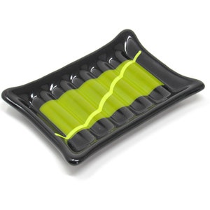 May include: A black glass soap dish with a lime green stripe and a wavy design.