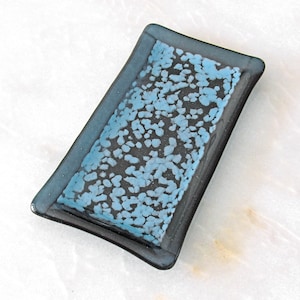 May include: A rectangular glass dish with a dark blue border and a light blue speckled pattern.