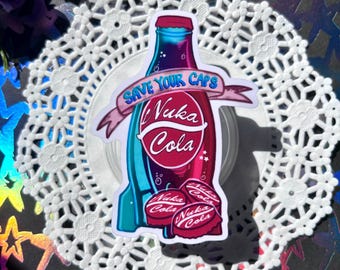 Puede incluir: Una pegatina de una botella de Nuka Cola azul y roja con el texto "Save Your Caps" y "Nuka Cola". Hay tres tapones de botella de Nuka Cola en la parte inferior de la pegatina.
