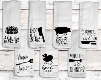 May include: Set of eight white kitchen towels with black text and graphics. The towels feature various food-related puns, such as "I like big bundts", "Chop it like it's hot", "Don't go bacon my heart", "Simmer the heck down", "Flippin' Awesome", "Let the beet drop", and "What the heck is for dinner?"