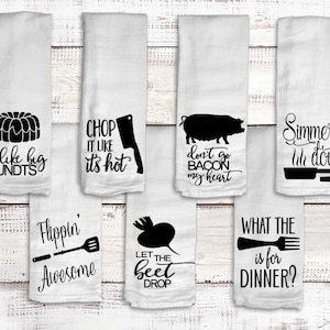 White kitchen flour sack towels with kitchen Puns. Sayings include I like big bunds with a bundt cake, Chop it like its hot with a chopping knife, Don't go bacon my heart with a pig, Don't let the beet drop with a beet.