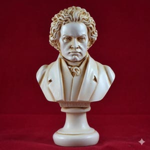 Può includere: Un busto color crema di Beethoven, con tratti del viso dettagliati e capelli ricci. Il busto è montato su un piedistallo con il nome "BEETHOVEN" inciso. La scultura è ambientata su uno sfondo rosso scuro, evidenziando l'opera d'arte classica.