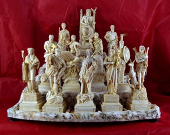 May include: A collection of detailed, off-white statues of Greek gods and goddesses, including Zeus, Athena, and Apollo. The figures are arranged on a decorative base with their names inscribed. The background is a solid red.