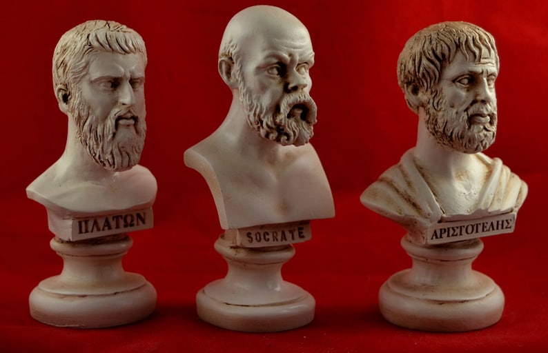 May include: Three white plaster busts of famous Greek philosophers on individual bases. The busts are of Plato, Socrates, and Aristophanes. Each bust has the philosopher's name inscribed on the base.