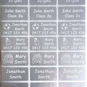 May include: A sheet of gray rectangular labels with white text. The labels display names like "Christina Le Geta," "John Smith Class 2a," and "Jonathan Smith" with a soccer ball icon and phone number. Other labels feature a cat or a girl icon.