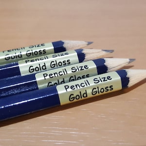 May include: Four blue pencils with gold labels that read "Pencil Size Gold Gloss".