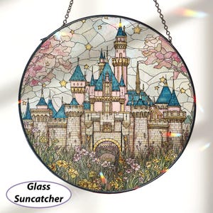 May include: Round glass suncatcher featuring a fairytale castle with pink, blue, and beige tones. The castle has multiple turrets and is surrounded by flowers and foliage. The suncatcher is suspended by a chain and has the words "Glass Suncatcher" on it.