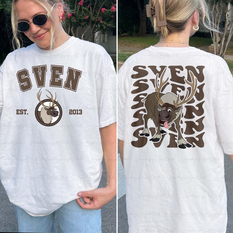Pode incluir: Camiseta branca com um gr&aacute;fico marrom de uma rena chamada Sven, com o texto "SVEN" acima e "EST. 2013" abaixo. A parte de tr&aacute;s apresenta um gr&aacute;fico maior de Sven e o nome repetido em um padr&atilde;o ondulado. Uma camiseta unissex casual.