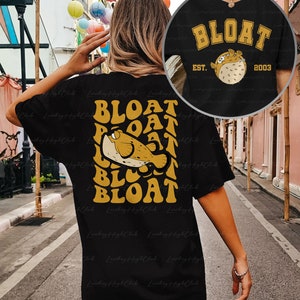 May include: Black t-shirt with a yellow graphic of a pufferfish and the text "BLOAT" repeated in a layered design. The text "EST. 2003" is also included on the shirt.