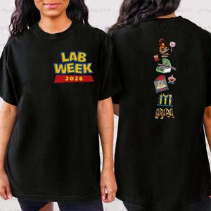May include: Black t-shirt with the text "LAB WEEK 2026" in yellow and blue lettering on the front. The back of the shirt features a vertical arrangement of colorful lab-related illustrations, including beakers and a microscope.