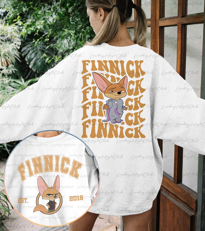 May include: A white sweatshirt with a cartoon fox wearing a purple robe and the word "FINNICK" repeated in a retro font. The sweatshirt also has a smaller image of the fox with the text "FINNICK EST. 2016" on the front.
