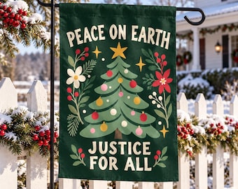Op de afbeelding: Een donkergroene tuin vlag met een centrale kerstboom versierd met kleurrijke ornamenten en een gele ster. De tekst PEACE ON EARTH staat bovenaan en JUSTICE FOR ALL onderaan, omringd door illustraties van bloemen en bessen.
