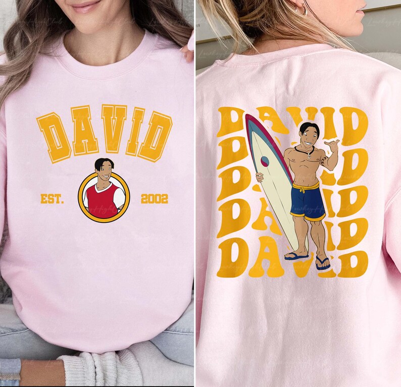 a woman wearing a pink shirt with a picture of a man holding a surfboard