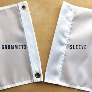 Puede incluir: Primer plano de una bandera blanca con la palabra "GROMMETS" en texto azul oscuro. La bandera tiene ojales dorados y una manga blanca con la palabra "SLEEVE" en texto azul oscuro.