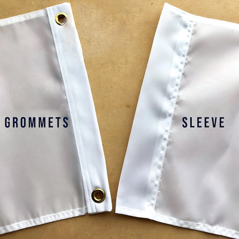 Puede incluir: Primer plano de una bandera blanca con la palabra "GROMMETS" en texto azul oscuro. La bandera tiene ojales dorados y una manga blanca con la palabra "SLEEVE" en texto azul oscuro.
