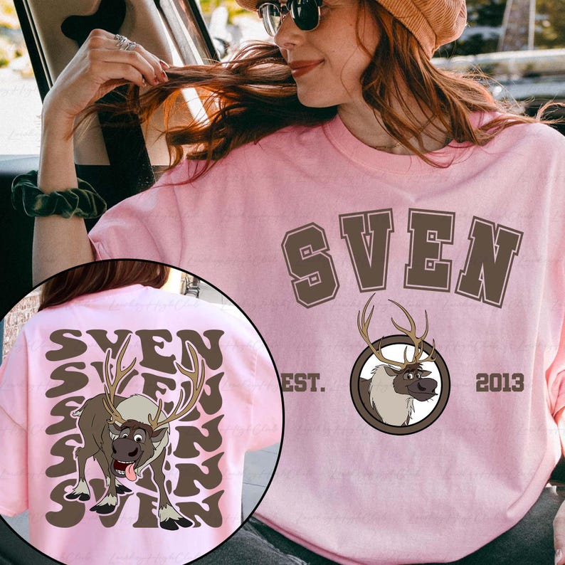 Pode incluir: Camiseta rosa claro com o nome "SVEN" em letras marrons. Um desenho animado de rena est&aacute; em um emblema circular. A parte de tr&aacute;s da camiseta tem o nome "SVEN" repetido com um gr&aacute;fico de rena. "EST. 2013" &eacute; impresso na frente.