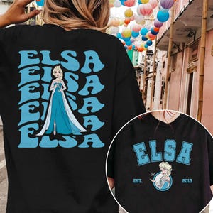 a woman wearing a black shirt with a picture of a frozen princess on it