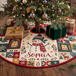 May include: A round quilted Christmas tree skirt featuring a central snowman wearing a hat and scarf, with the name Sophia printed in red script. The border consists of patchwork squares displaying winter scenes, snowflakes, and holly motifs.