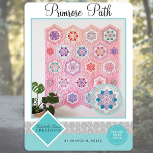Puede incluir: Un patrón de acolchado llamado "Primrose Path" de Libelulle Lane Creations. El patrón presenta un fondo rosa con una variedad de diseños florales coloridos. El patrón es para el acolchado de papel inglés.