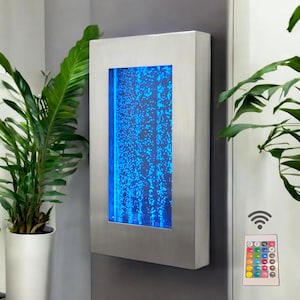 May include: A stainless steel bubble wall with a blue LED light and a remote control to change the color of the light. The wall is mounted on a white wall.